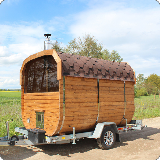 Eine Fass-Sauna auf einem Anhänger, wodurch diese mobil an verschiedenen Orten einsetzbar ist.
